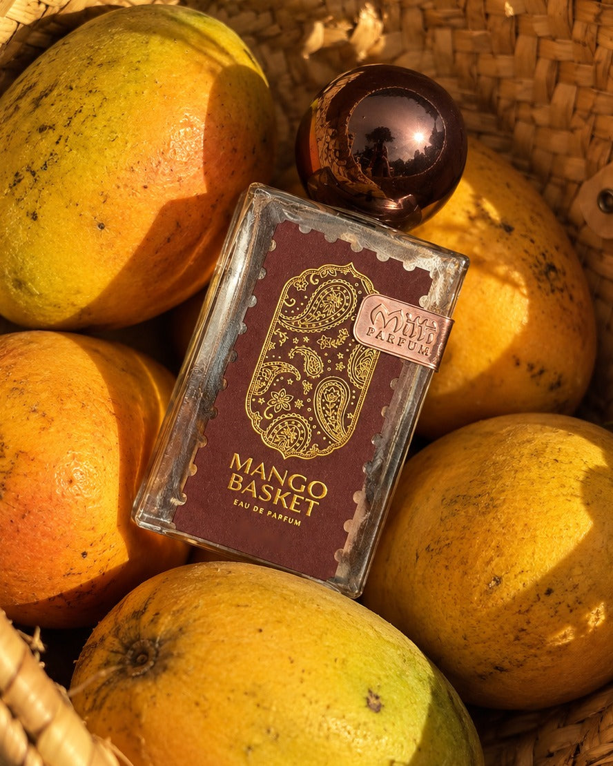 Mango Basket Eau de Parfum resting on ripe mangoes in a woven basket.